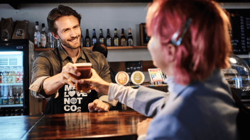 Bartender giver et glas øl til kunde