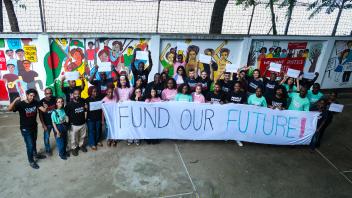 Klima aktivister i Bangladesh, står med et banner hvor der står "Fund Our Future"