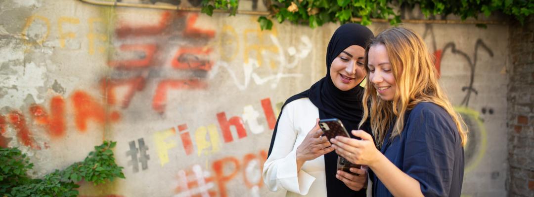 Personer kigger på telefon sammen