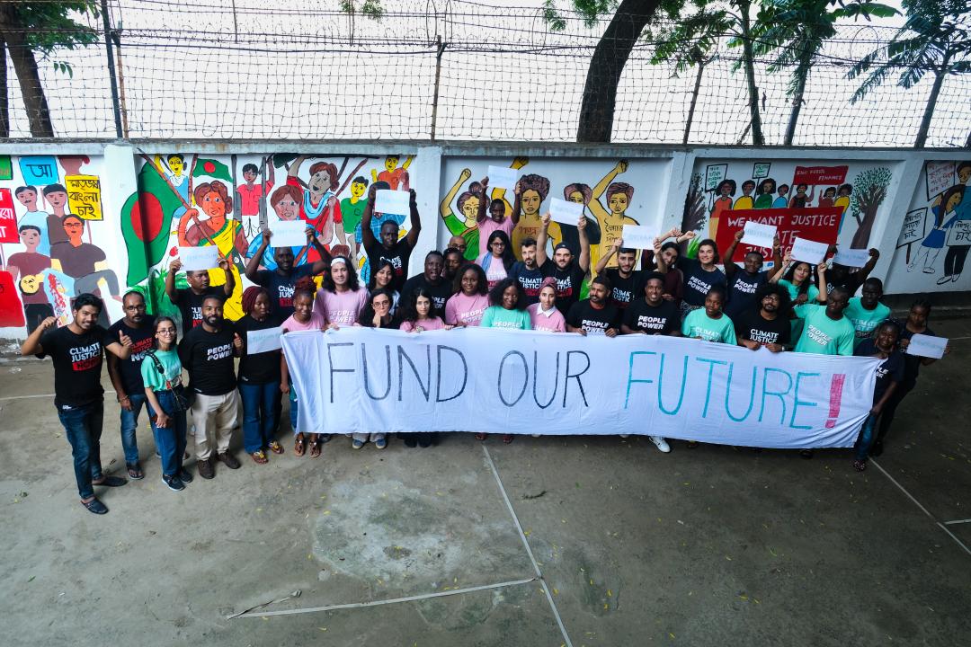 Klima aktivister i Bangladesh, står med et banner hvor der står "Fund Our Future"